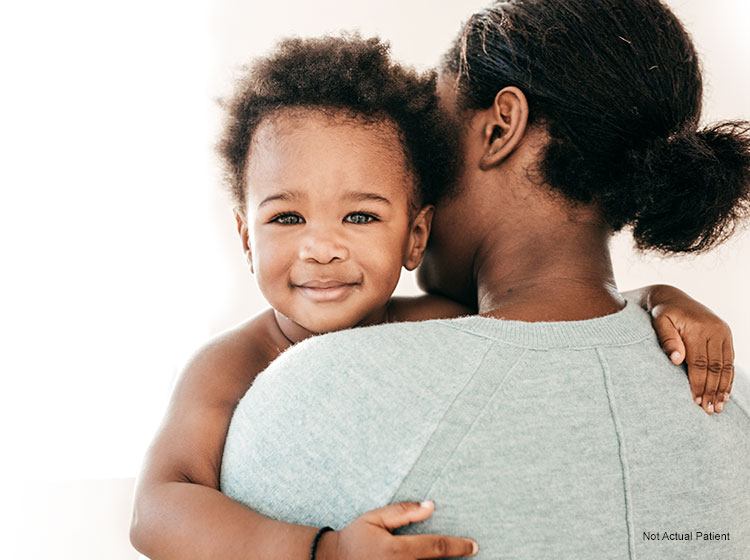 baby smiling over mom's shoulder